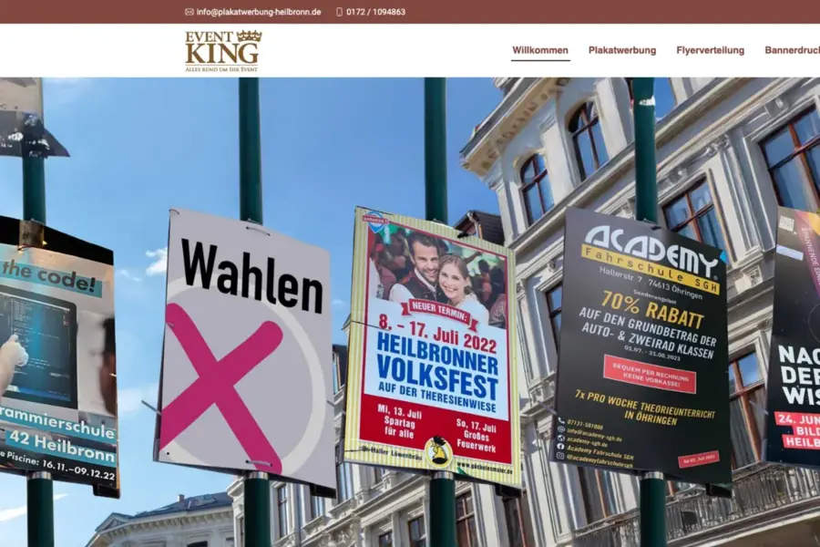 Startseite von Event King: eine Reihe von Plakattafeln an Laternenmasten vor Altbaufassaden in der Heilbronner Innenstadt.